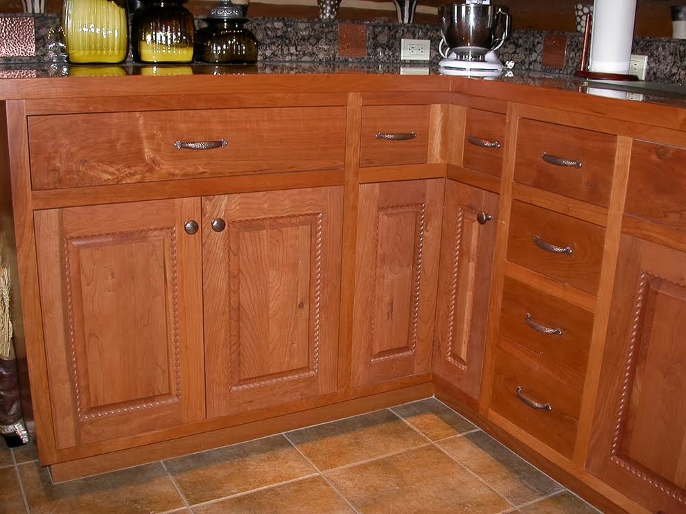 Example of a mid-sized transitional l-shaped medium tone wood floor eat-in kitchen design in Seattle with an undermount sink, shaker cabinets, dark wood cabinets, granite countertops, red backsplash, mosaic tile backsplash, stainless steel appliances and an island