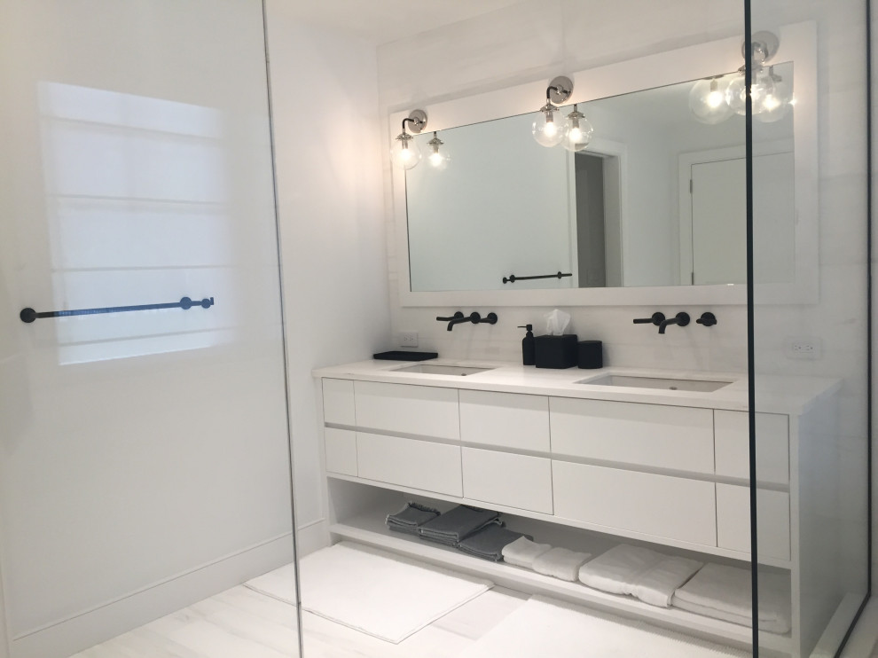 This is an example of a mid-sized contemporary master bathroom in New York with flat-panel cabinets, an undermount sink, white benchtops, a double vanity and a built-in vanity.