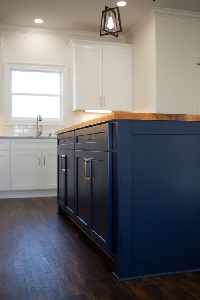 Eat-in kitchen - mid-sized craftsman l-shaped vinyl floor and brown floor eat-in kitchen idea in Other with a single-bowl sink, shaker cabinets, blue cabinets, wood countertops, white backsplash, subway tile backsplash, stainless steel appliances, an island and brown countertops