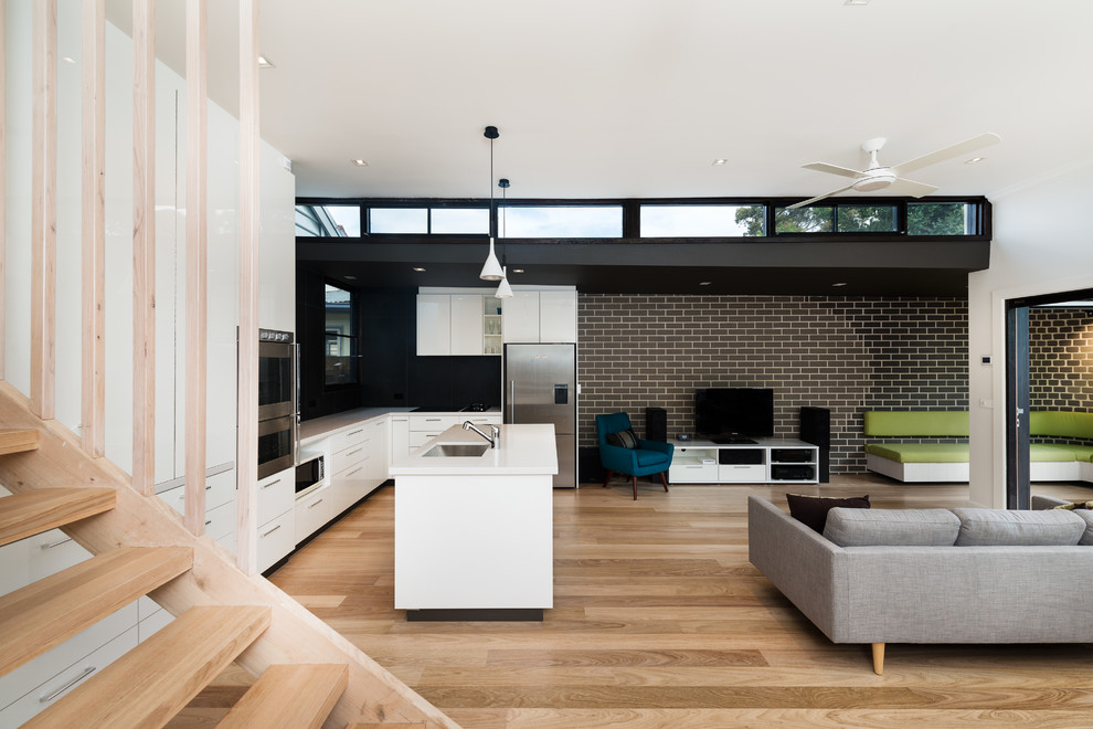 This is an example of a contemporary open concept living room in Melbourne with a freestanding tv.