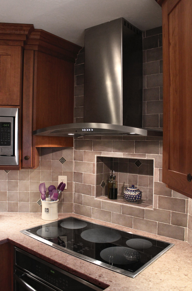 Example of a large transitional u-shaped light wood floor eat-in kitchen design in Boston with an undermount sink, shaker cabinets, medium tone wood cabinets, quartz countertops, gray backsplash, porcelain backsplash, stainless steel appliances and a peninsula