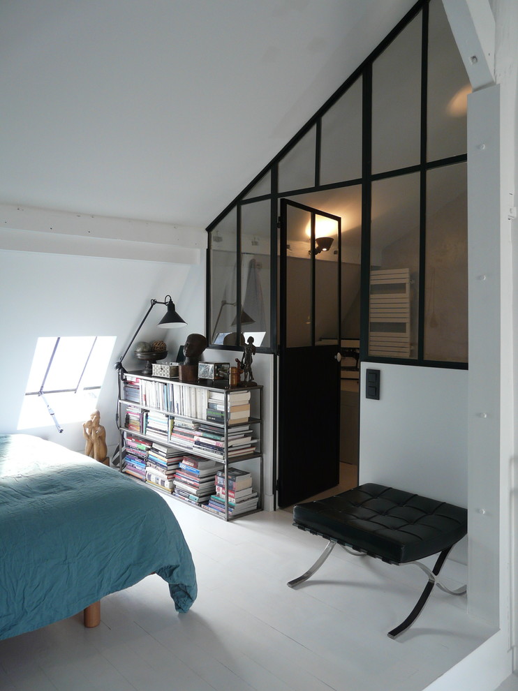 Design ideas for a mid-sized industrial loft-style bedroom in Paris with white walls and painted wood floors.