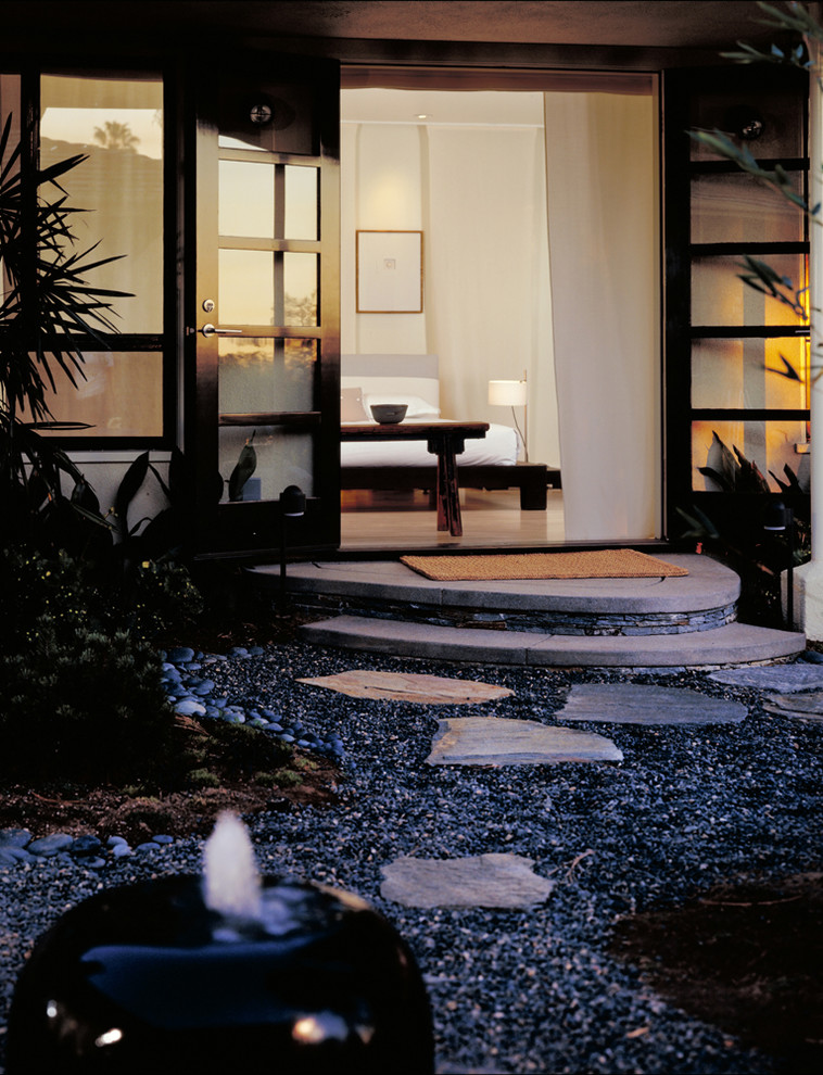 This is an example of a mid-sized asian backyard partial sun formal garden in Los Angeles with a water feature and gravel.