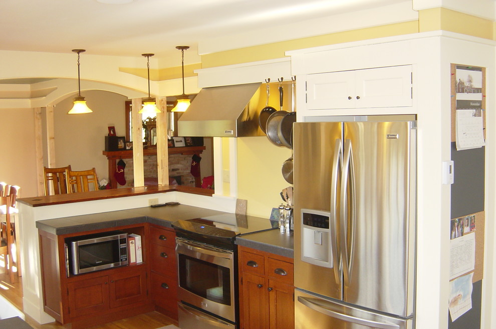 Example of a mid-sized arts and crafts galley light wood floor eat-in kitchen design in Burlington with a farmhouse sink, flat-panel cabinets, dark wood cabinets, tile countertops, green backsplash, ceramic backsplash, stainless steel appliances and no island
