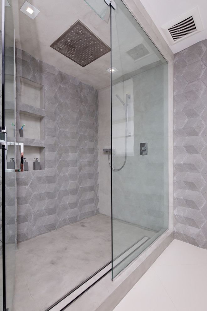 Photo of a small contemporary 3/4 bathroom in Miami with flat-panel cabinets, light wood cabinets, concrete benchtops, a corner shower, a wall-mount toilet, black tile and cement tile.