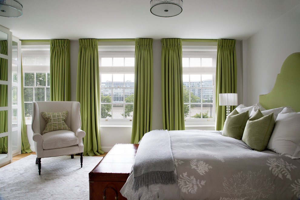 Transitional master bedroom in London with grey walls and light hardwood floors.