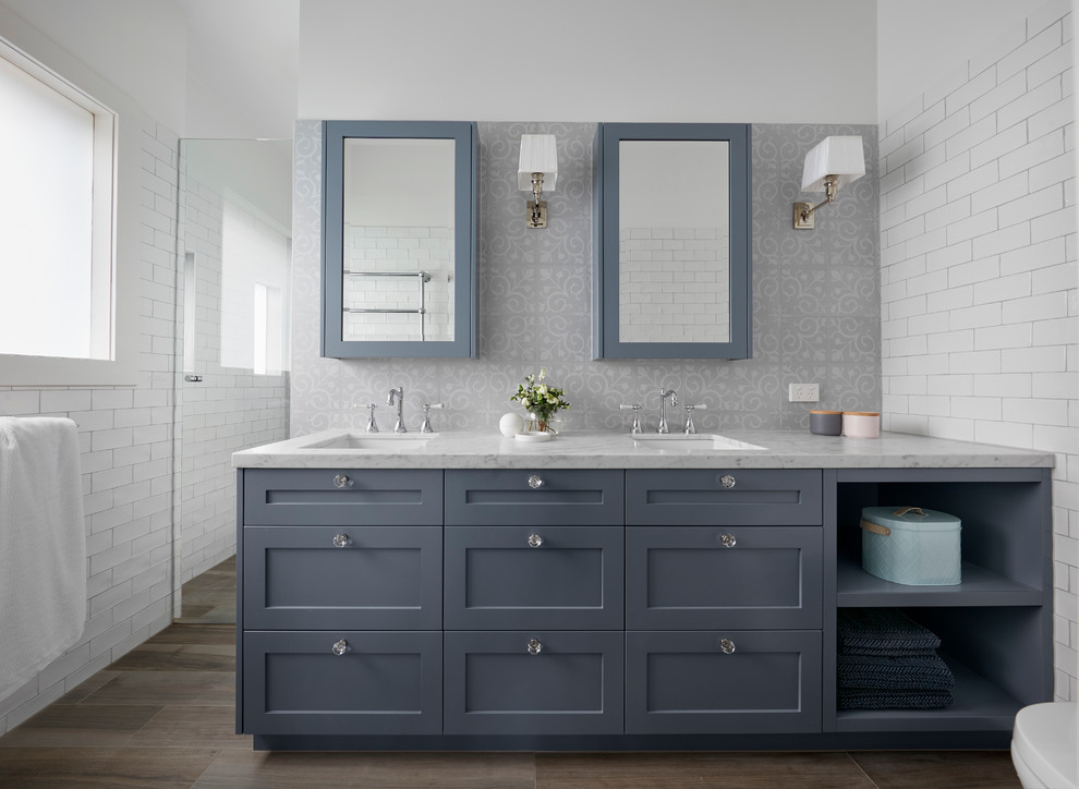 Design ideas for a mid-sized transitional 3/4 bathroom in Melbourne with furniture-like cabinets, grey cabinets, a freestanding tub, a corner shower, multi-coloured tile, subway tile, white walls, plywood floors, an integrated sink, marble benchtops, brown floor, an open shower and white benchtops.