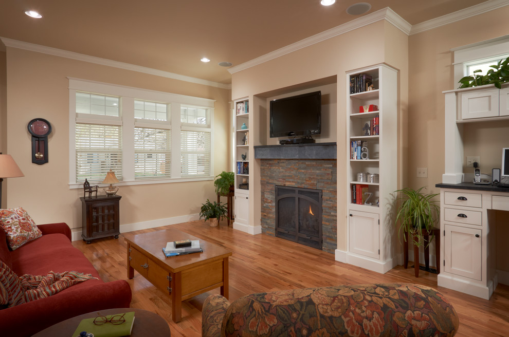 Photo of a mid-sized arts and crafts open concept living room in Denver with red walls, medium hardwood floors, a standard fireplace, a stone fireplace surround, a built-in media wall and brown floor.