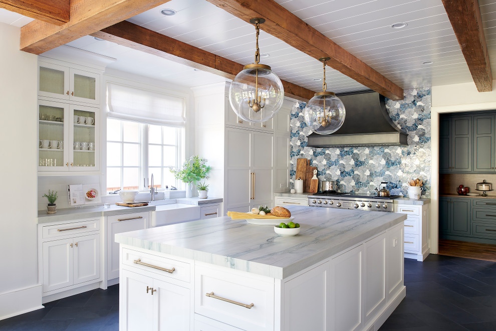 Inspiration for a large slate floor, gray floor and exposed beam enclosed kitchen remodel in Philadelphia with a farmhouse sink, recessed-panel cabinets, white cabinets, quartzite countertops, blue backsplash, glass tile backsplash, paneled appliances, two islands and blue countertops