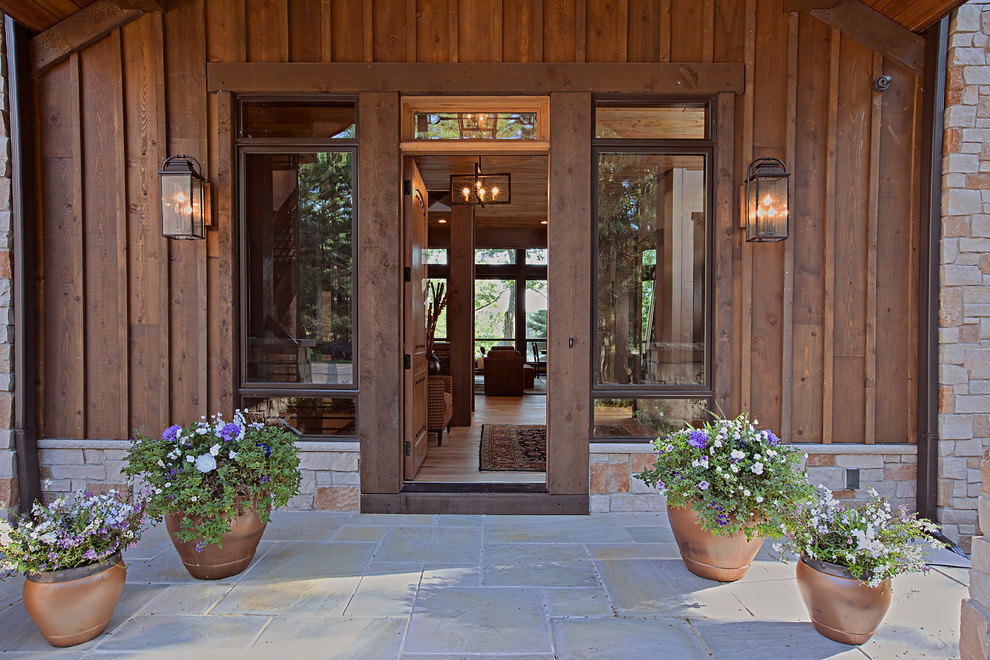Photo of a country front door in Other with a single front door, a medium wood front door and grey floor.