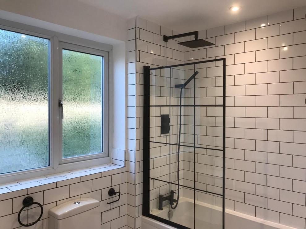 This is an example of a small industrial kids bathroom in London with flat-panel cabinets, white cabinets, a corner tub, a corner shower, a one-piece toilet, white tile, ceramic tile, white walls, mosaic tile floors, a console sink, multi-coloured floor, a single vanity and a freestanding vanity.