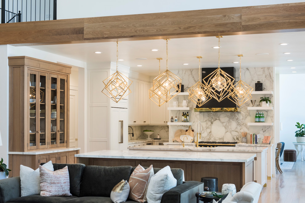 Design ideas for a large contemporary l-shaped eat-in kitchen in Salt Lake City with a farmhouse sink, shaker cabinets, white cabinets, marble benchtops, white splashback, marble splashback, panelled appliances, medium hardwood floors, multiple islands and brown floor.