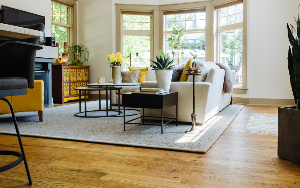 Photo of a mid-sized arts and crafts formal open concept living room in Nashville with white walls, medium hardwood floors, a standard fireplace, a wood fireplace surround, a wall-mounted tv and brown floor.