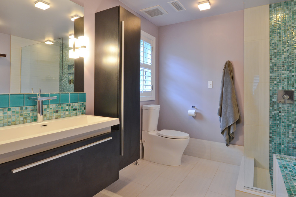 Small eclectic master bathroom in Boston with an integrated sink, flat-panel cabinets, dark wood cabinets, a drop-in tub, an open shower, a two-piece toilet, green tile, glass tile, purple walls and porcelain floors.