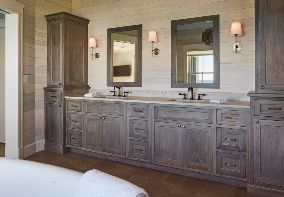 This is an example of a beach style master bathroom in Portland Maine with shaker cabinets, dark wood cabinets, beige walls, an undermount sink, brown floor and beige benchtops.