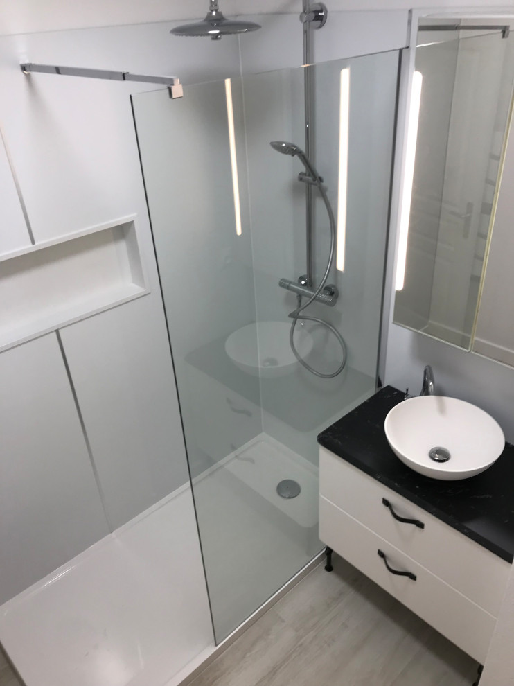 Kleines Modernes Duschbad mit offener Dusche, Kieselfliesen, weißer Wandfarbe, Vinylboden, Waschtischkonsole, weißem Boden, Wandnische und Einzelwaschbecken in Marseille