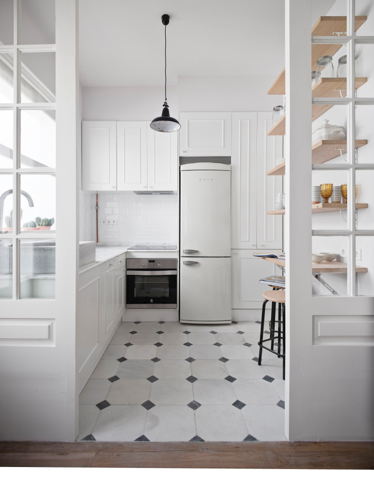 Photo of a scandinavian l-shaped separate kitchen in Other with recessed-panel cabinets, white cabinets, white splashback, subway tile splashback, white appliances, no island, white floor and white benchtop.