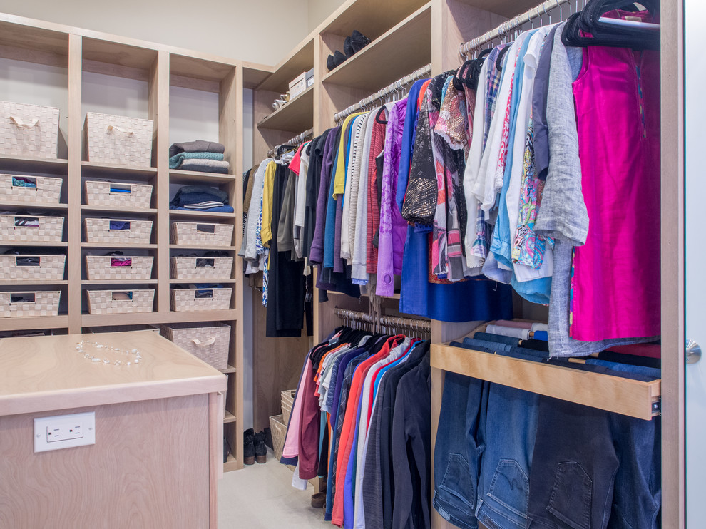 This is an example of a mid-sized transitional gender-neutral walk-in wardrobe in Seattle with flat-panel cabinets, grey cabinets, ceramic floors, beige floor and vaulted.