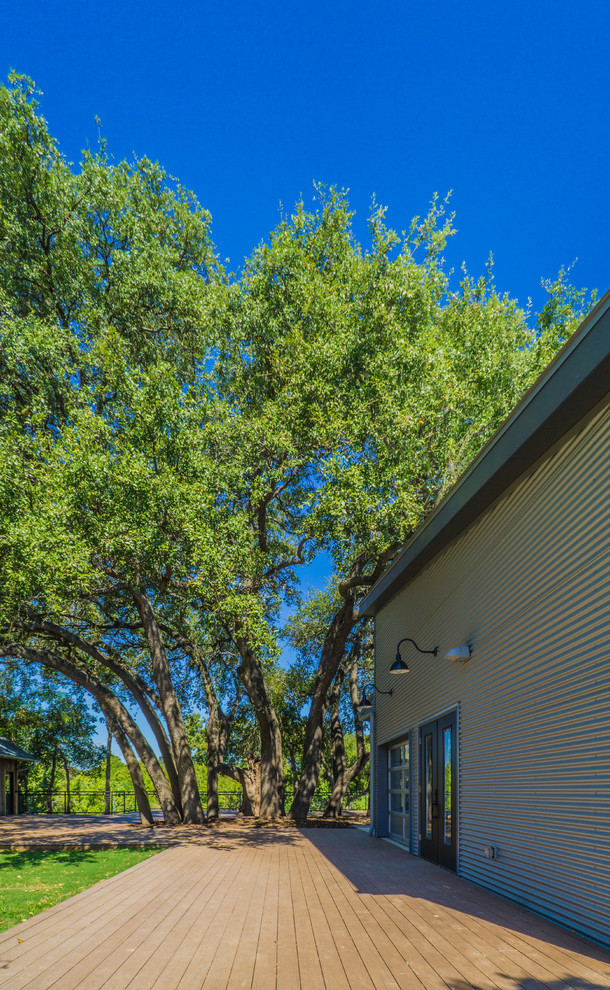 This is an example of an expansive midcentury backyard deck in Austin with an awning.