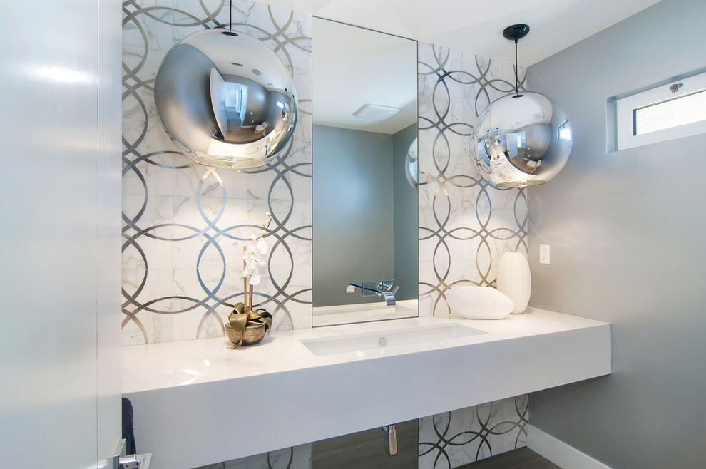 This is an example of a mid-sized contemporary powder room in San Diego with white tile, grey walls, an undermount sink, engineered quartz benchtops and white benchtops.