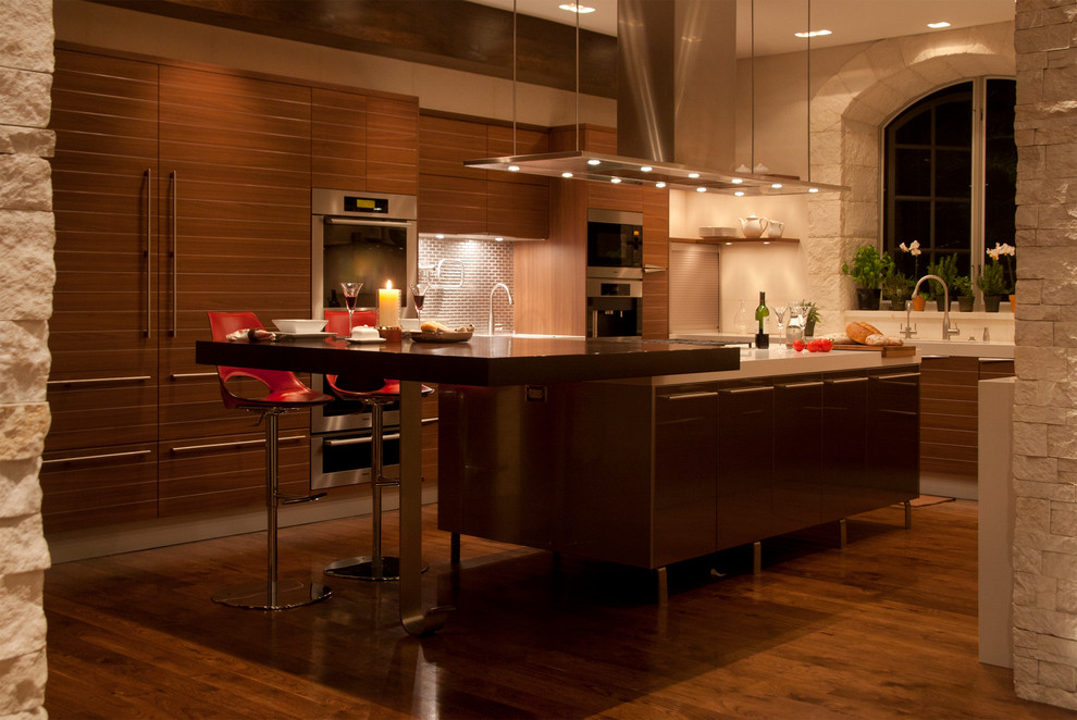 Photo of a large contemporary u-shaped eat-in kitchen in Los Angeles with a double-bowl sink, flat-panel cabinets, medium wood cabinets, quartz benchtops, beige splashback, panelled appliances, medium hardwood floors and metal splashback.