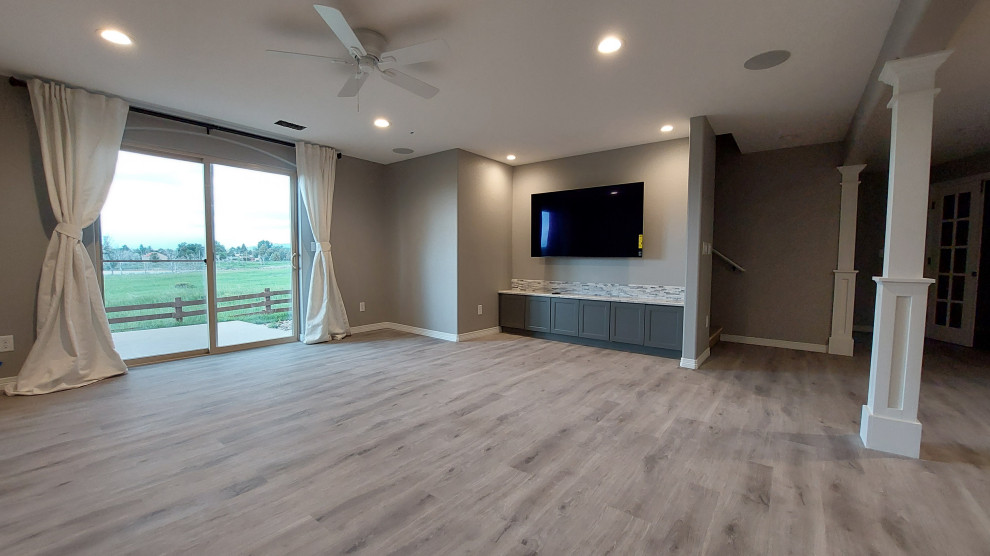 Exemple d'une salle de séjour chic avec un sol en vinyl, un téléviseur fixé au mur et un sol gris.