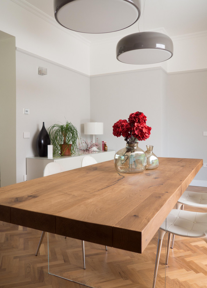 Large contemporary dining room in Other with grey walls, light hardwood flooring, a standard fireplace and a stone fireplace surround.