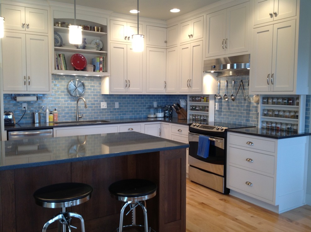 Inspiration for a mid-sized farmhouse l-shaped light wood floor eat-in kitchen remodel with an undermount sink, granite countertops, blue backsplash, ceramic backsplash, stainless steel appliances and an island