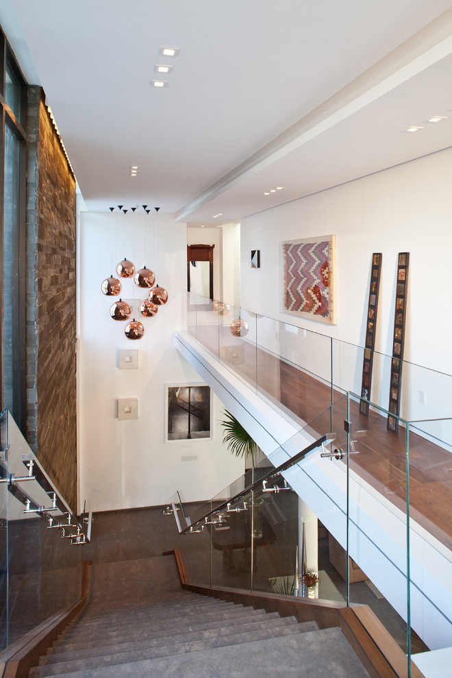 Photo of a large contemporary hallway in Miami with white walls, concrete floors and brown floor.