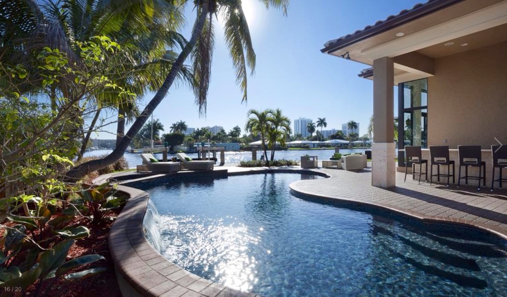 Photo of a mid-sized mediterranean backyard kidney-shaped pool in Miami.
