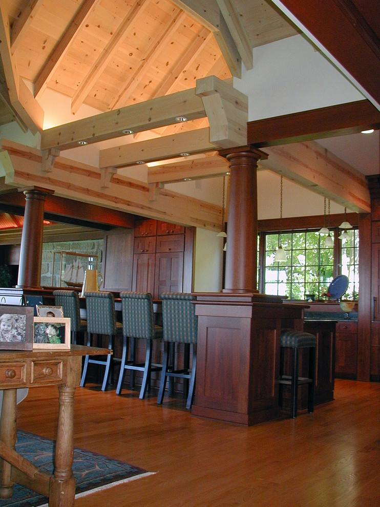 Inspiration for a mid-sized rustic galley medium tone wood floor eat-in kitchen remodel in Cleveland with a double-bowl sink, shaker cabinets, medium tone wood cabinets, granite countertops, black backsplash, stone slab backsplash, stainless steel appliances and an island