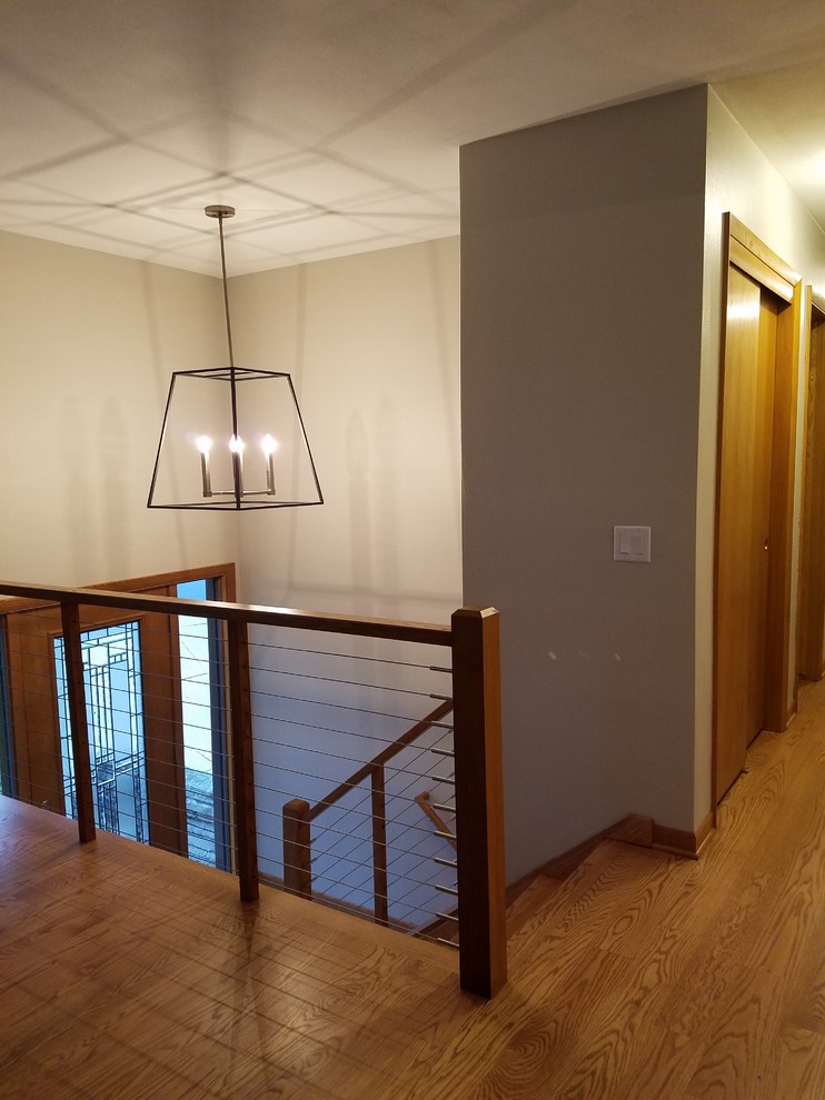 Inspiration for a mid-sized transitional u-shaped medium tone wood floor and brown floor home design remodel with an undermount sink, shaker cabinets, white cabinets, quartz countertops, white backsplash, subway tile backsplash, stainless steel appliances and a peninsula