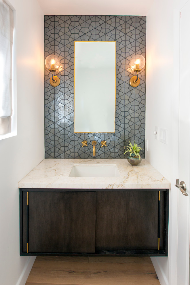 Contemporary powder room in Los Angeles with flat-panel cabinets, dark wood cabinets, gray tile, white walls, light hardwood floors, an undermount sink and beige floor.