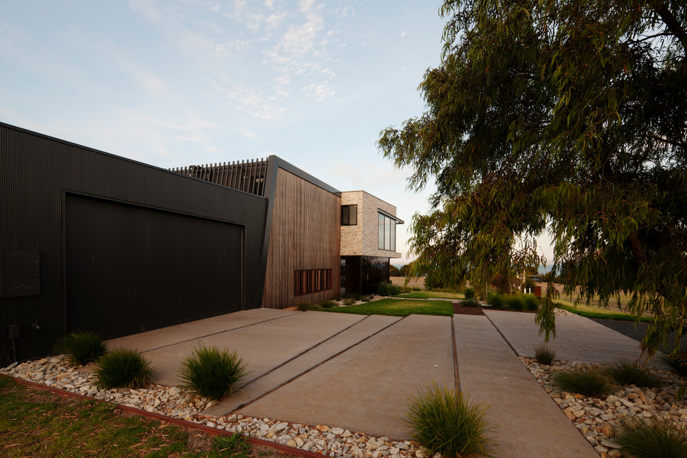 Inspiration for a large contemporary two-storey house exterior in Melbourne with wood siding, a flat roof and a metal roof.