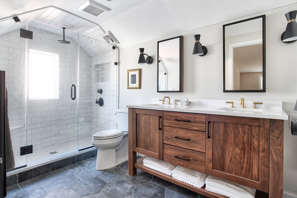 Photo of a mid-sized transitional master bathroom in New York with shaker cabinets, medium wood cabinets, an alcove shower, a two-piece toilet, white tile, beige walls, porcelain floors, an undermount sink, quartzite benchtops, black floor, a hinged shower door and white benchtops.