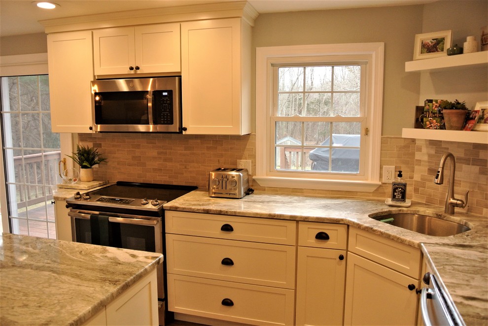 Transitional l-shaped medium tone wood floor kitchen photo in Boston with an undermount sink, shaker cabinets, white cabinets, granite countertops, beige backsplash, subway tile backsplash, stainless steel appliances and an island