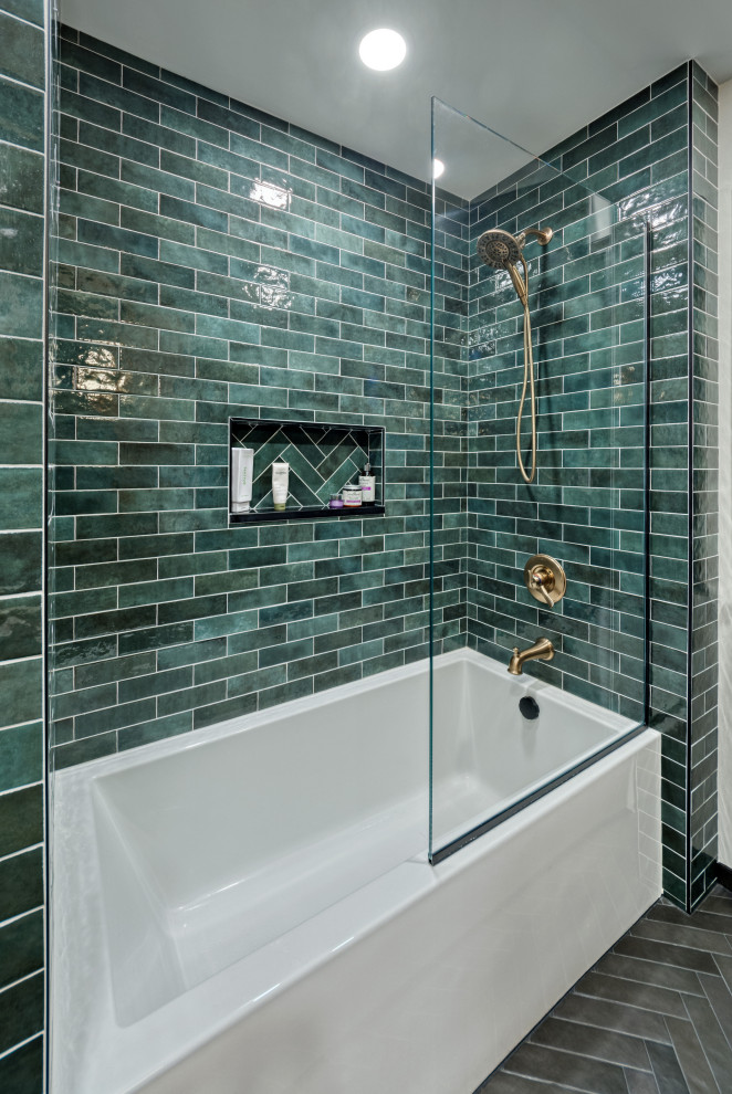 Medium sized retro ensuite bathroom in Minneapolis with flat-panel cabinets, light wood cabinets, an alcove bath, a shower/bath combination, a two-piece toilet, green tiles, ceramic tiles, white walls, ceramic flooring, a submerged sink, engineered stone worktops, black floors, an open shower, black worktops, a wall niche, a single sink and a built in vanity unit.