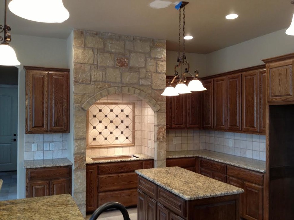 Inspiration for a mid-sized rustic l-shaped ceramic tile eat-in kitchen remodel in Austin with an undermount sink, raised-panel cabinets, granite countertops, beige backsplash, ceramic backsplash, stainless steel appliances, an island and dark wood cabinets