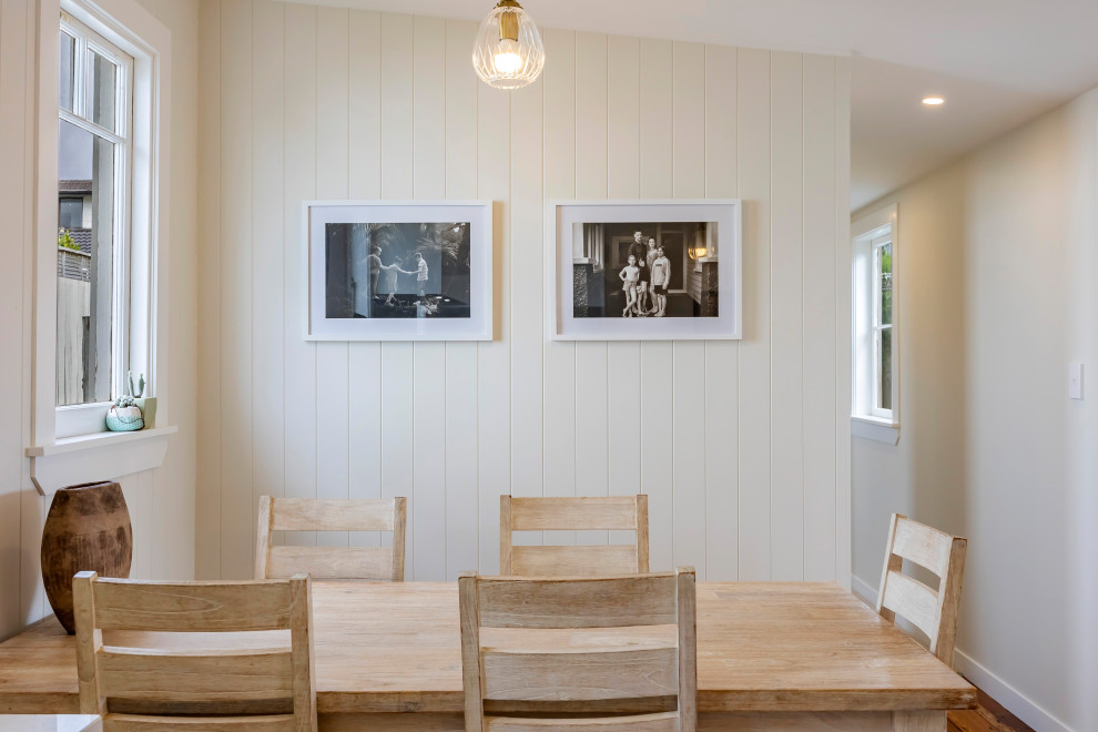 Kleine Klassische Wohnküche mit weißer Wandfarbe, braunem Holzboden und Holzdielenwänden in Auckland