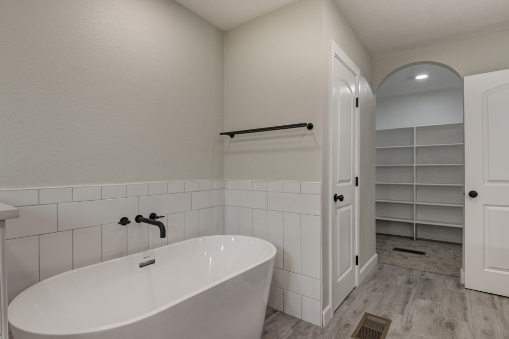 Example of a mid-sized transitional master white tile and subway tile double-sink freestanding bathtub design in Phoenix with shaker cabinets, brown cabinets, an undermount sink, quartz countertops, white countertops and a built-in vanity