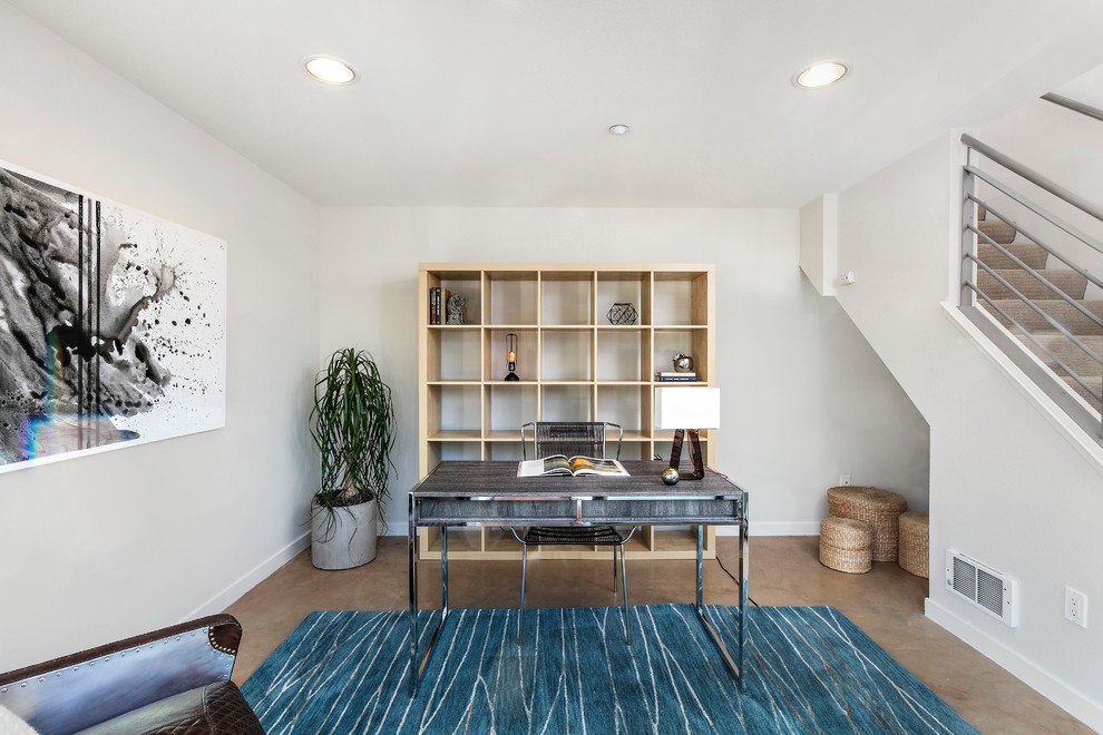 This is an example of a contemporary study room in San Francisco with white walls, carpet, a freestanding desk and beige floor.