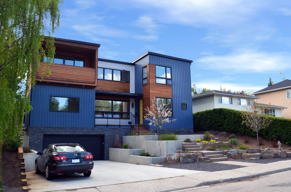 Contemporary two-storey blue exterior in Calgary with mixed siding.