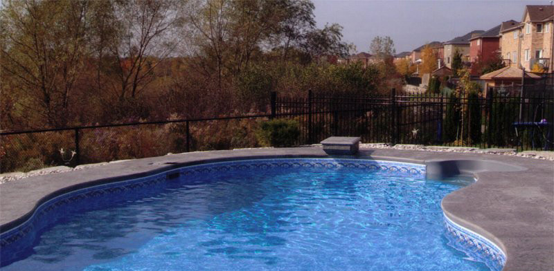 Mid-sized backyard concrete paver and custom-shaped lap pool photo