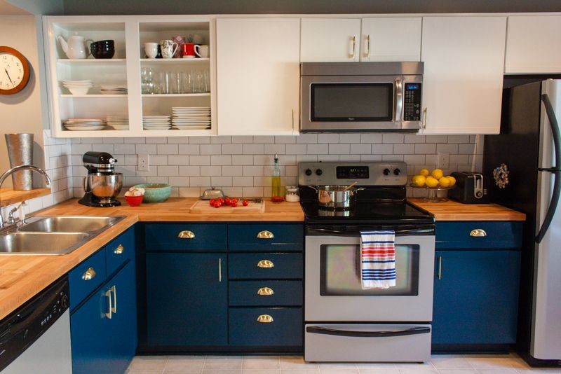 Inspiration for a small transitional l-shaped separate kitchen in Richmond with a drop-in sink, flat-panel cabinets, blue cabinets, wood benchtops, white splashback, subway tile splashback, stainless steel appliances, vinyl floors, no island and beige floor.