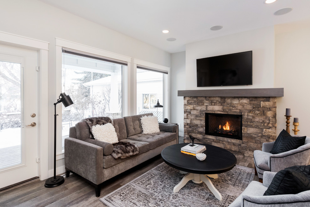 Small transitional formal open concept living room in Other with grey walls, vinyl floors, a standard fireplace, a stone fireplace surround, a wall-mounted tv and brown floor.
