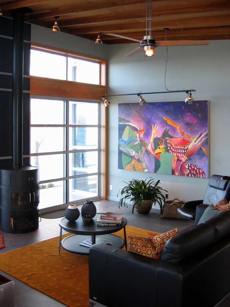 This is an example of a contemporary living room in Seattle with blue walls and a wood stove.