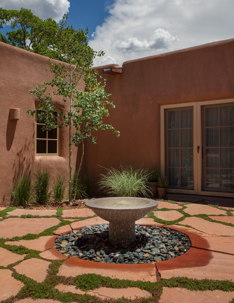 Inspiration for a large one-storey adobe brown exterior in Albuquerque with a flat roof.