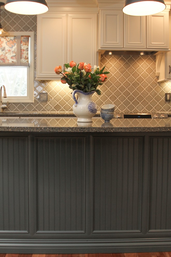 Eat-in kitchen - mid-sized traditional u-shaped medium tone wood floor eat-in kitchen idea in Indianapolis with an undermount sink, recessed-panel cabinets, white cabinets, granite countertops, gray backsplash, glass tile backsplash, stainless steel appliances and an island