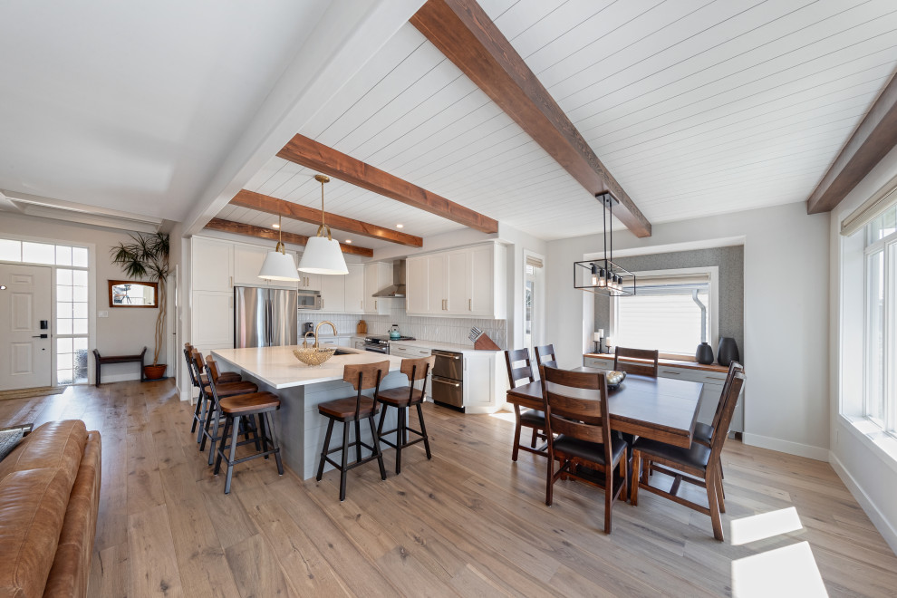 Mid-sized country open plan dining in Edmonton with white walls, vinyl floors, a two-sided fireplace, brown floor and timber.