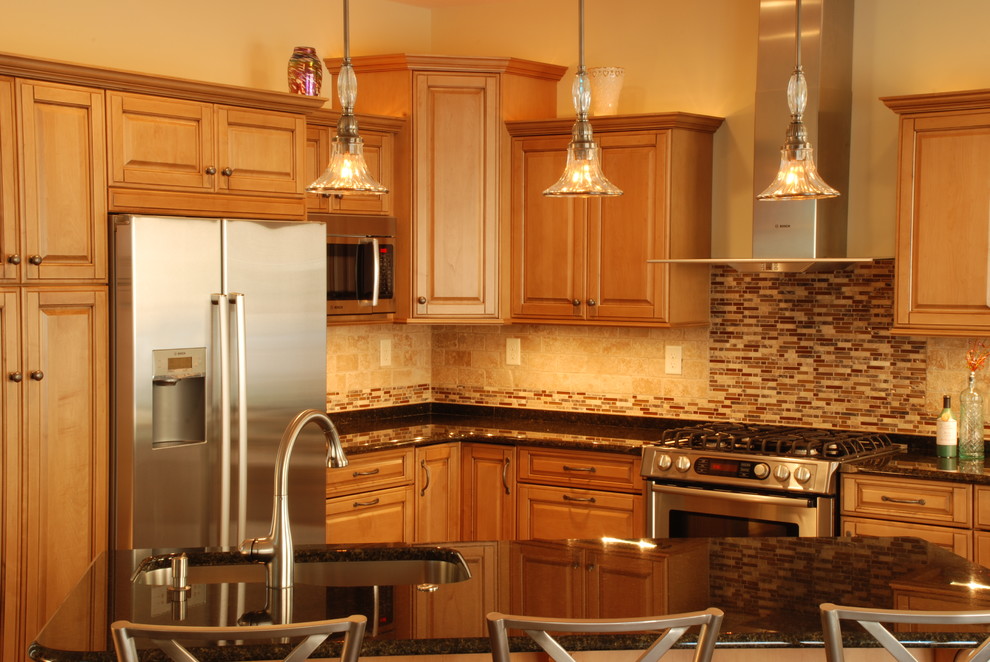 Mid-sized transitional l-shaped ceramic tile eat-in kitchen photo with a farmhouse sink, raised-panel cabinets, medium tone wood cabinets, granite countertops, beige backsplash, ceramic backsplash, stainless steel appliances and an island